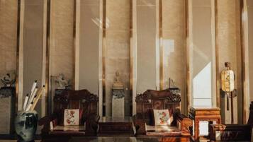 A traditional room with two wooden chairs, a table, and a decorative vase.