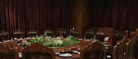 Une salle de conférence équipée d’une table ronde, de chaises et d’un arrangement floral en guise de décoration centrale.