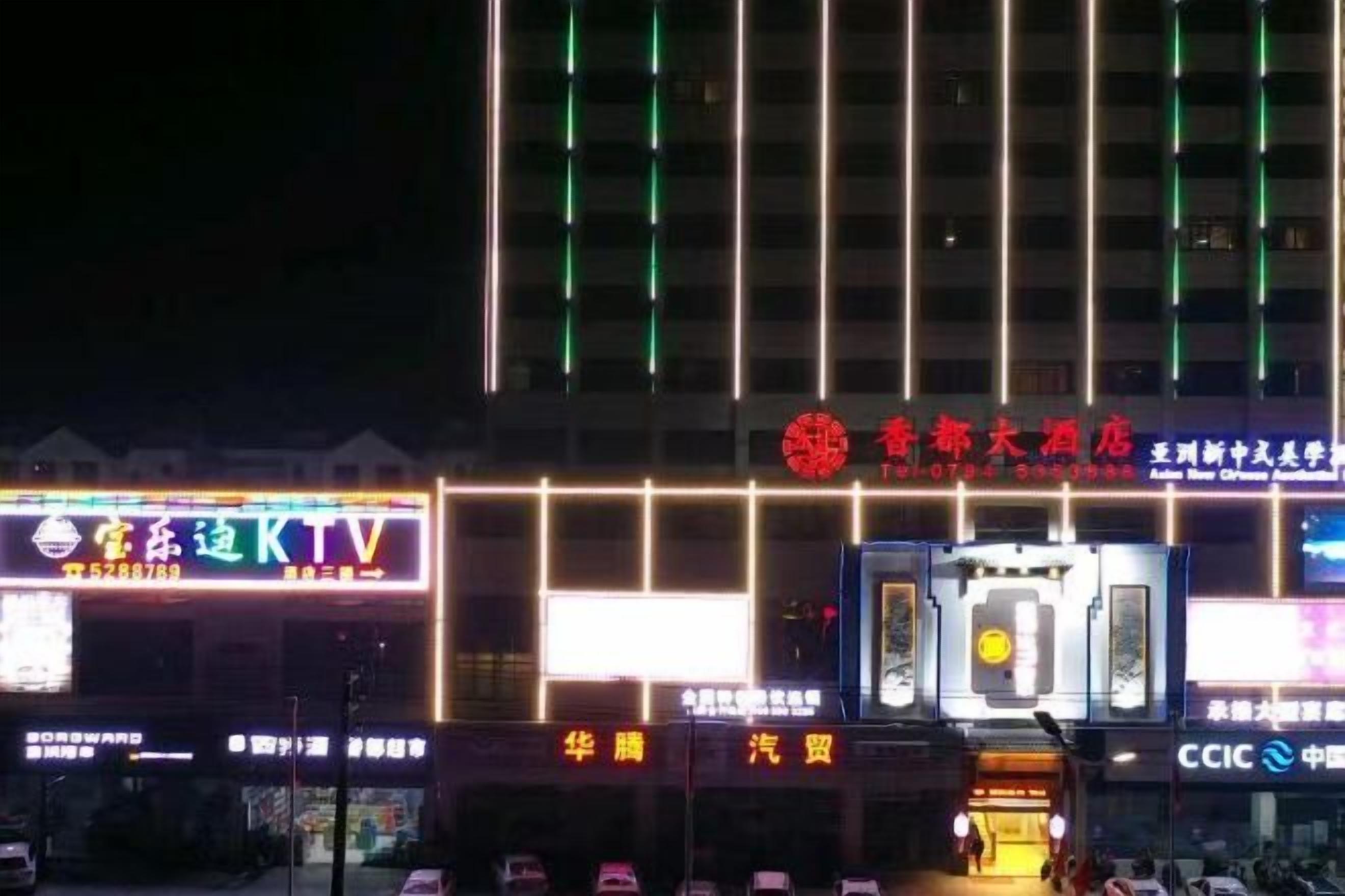 A building with illuminated signage, a prominent red logo, and multiple light strips.