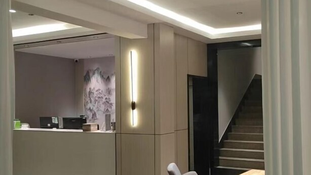 A modern interior with a dining area, a staircase, and a reception desk. - JYhotel (Yuyao)
