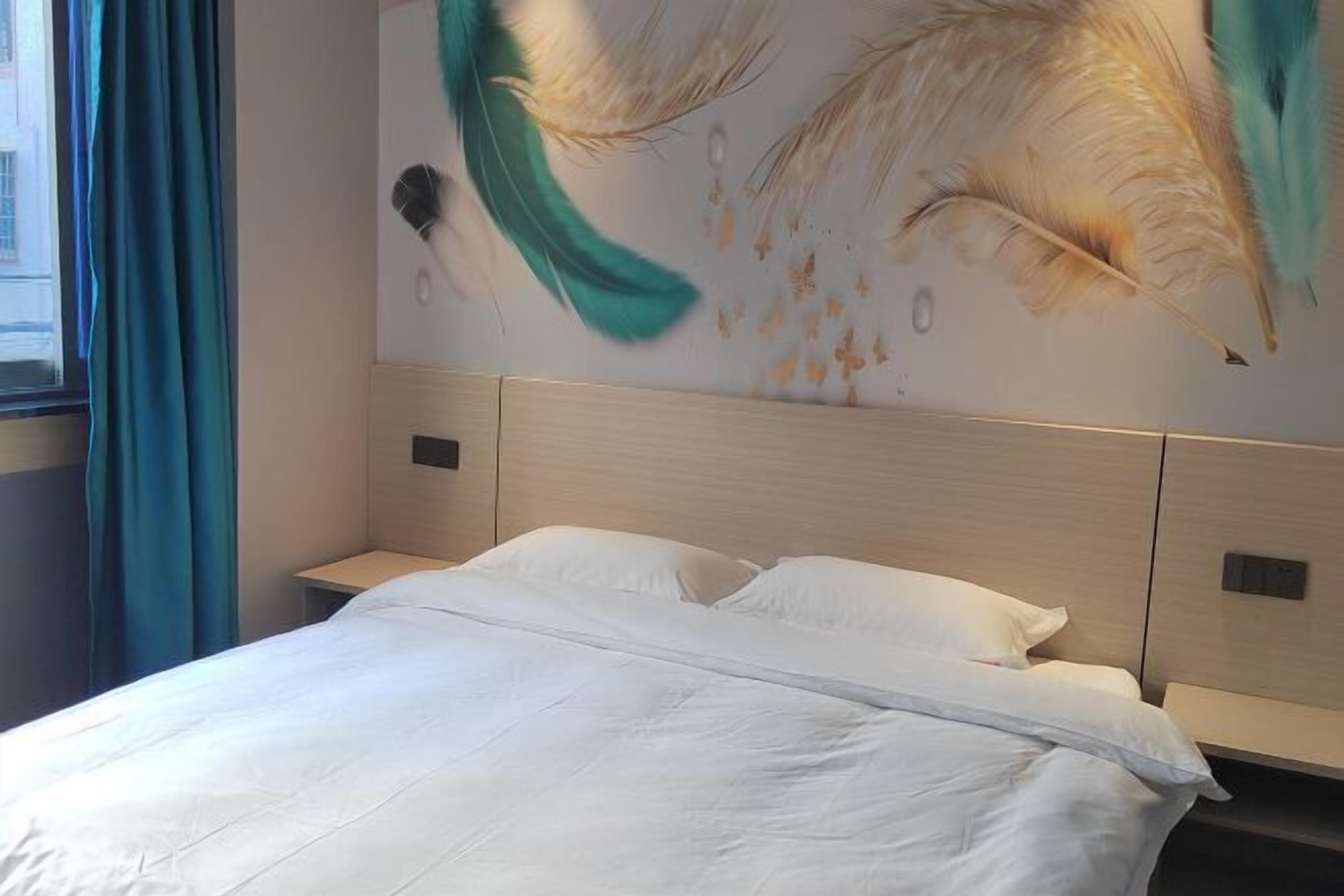 Una habitación de hotel con una cama, una mesita de noche y un mural en la pared.
