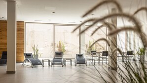 A spacious indoor area with modern seating arrangements and large windows providing natural light. - Apartment with 3 bedrooms and private sauna (Rohrmoos-Untertal)