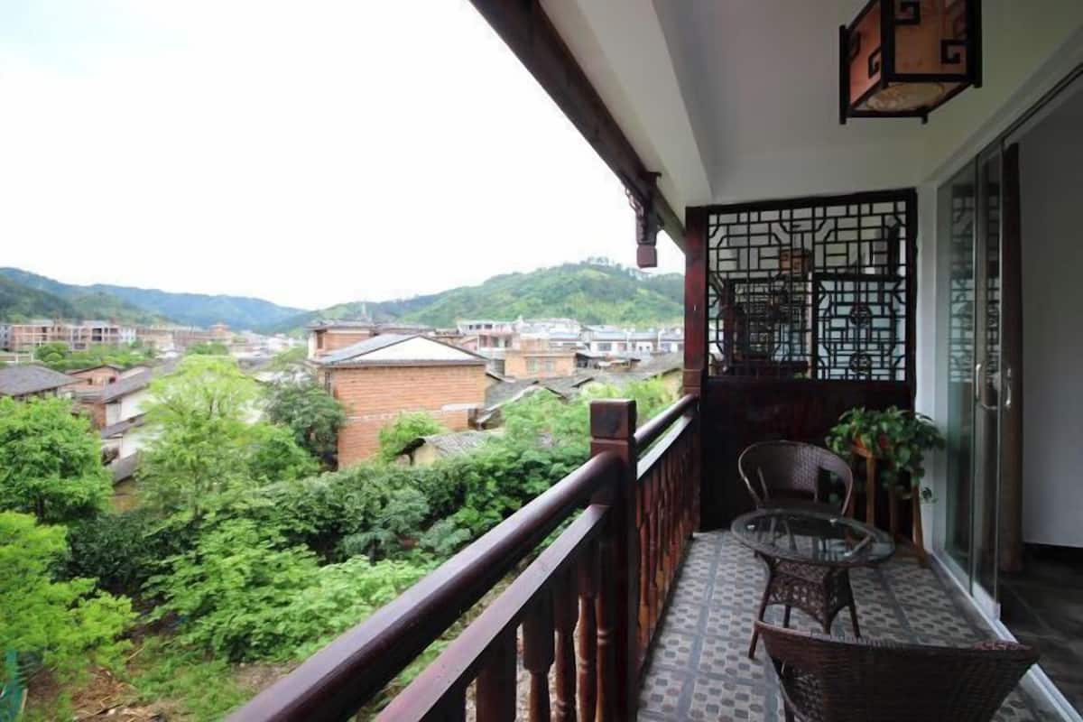 A balcony with a view of a residential area and hills.