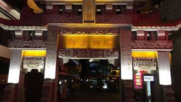 Una entrada ornamentada con arquitectura china tradicional, que incluye tallados intrincados y una gran placa dorada.