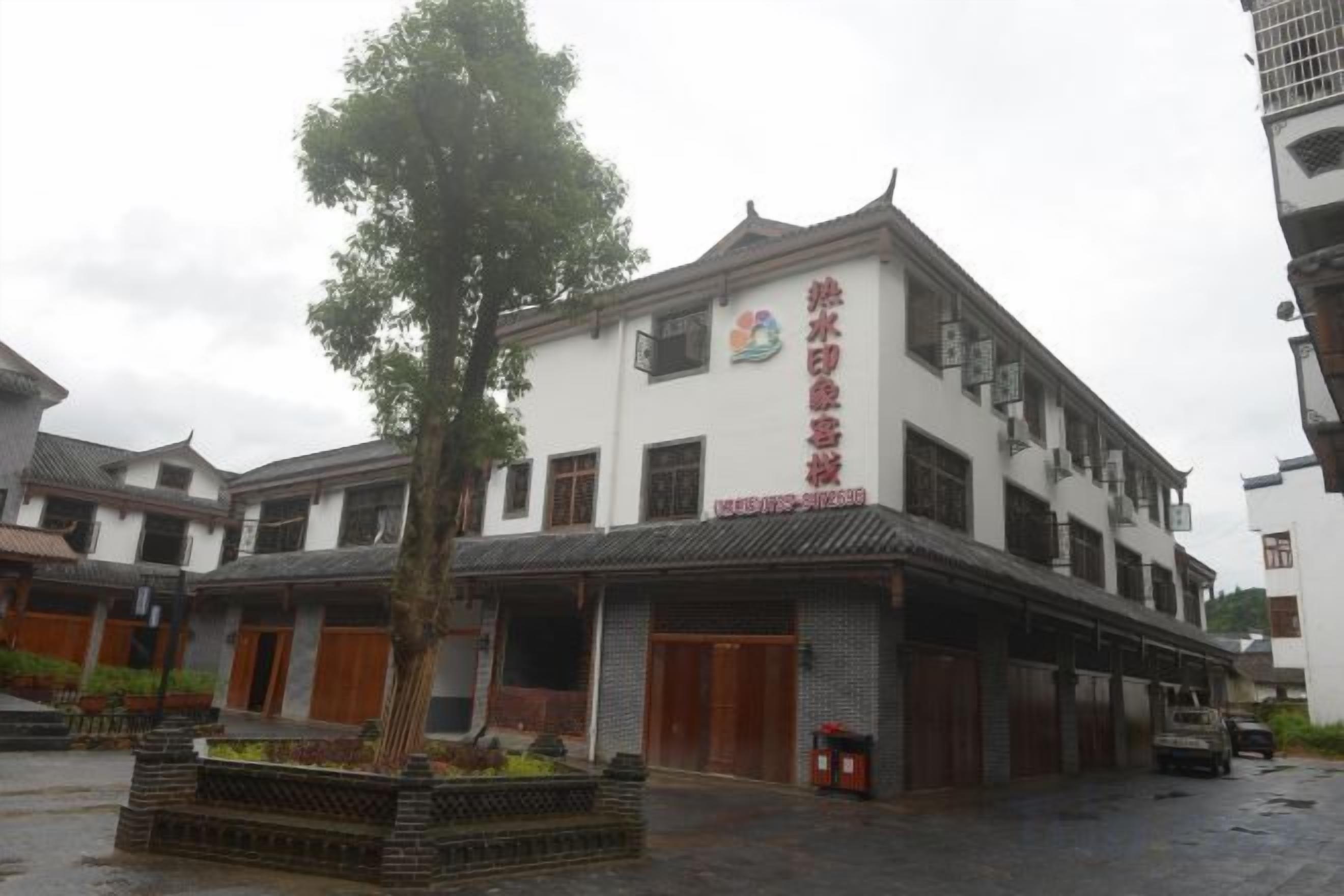 A traditional building with a prominent sign, multiple doors, and a courtyard with a tree.