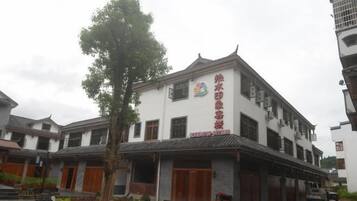 A traditional building with a prominent sign, multiple doors, and a courtyard with a tree.