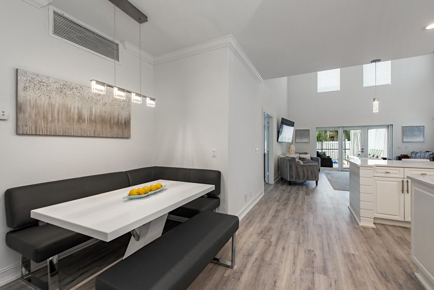 A modern kitchen with white cabinets and a grey countertop.