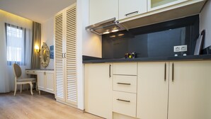 Una cocina moderna con armarios de colores claros, encimera negra y estufa integrada.