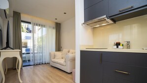 Una cocina moderna con armarios oscuros, encimera blanca y estufa integrada.