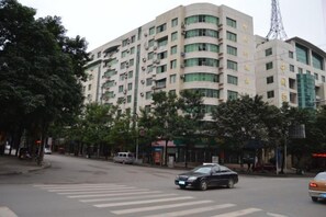 A multi-story building with a modern architectural design, featuring a prominent entrance and a visible antenna structure. - The westside Lancaster Hotel (Xichong)