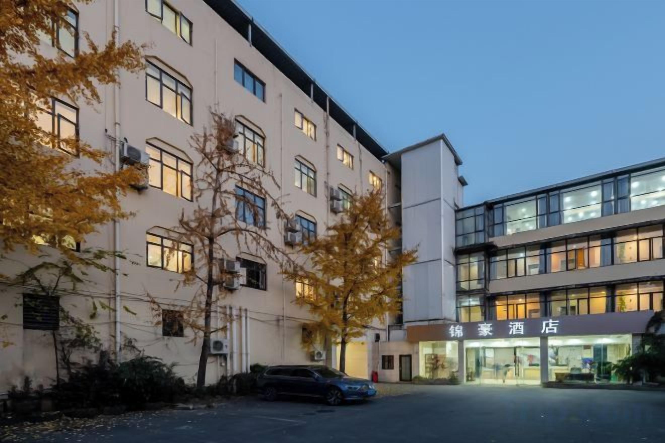 Un hôtel comprenant plusieurs étages, un espace de stationnement et une enseigne indiquant qu’il s’agit d’un hôtel.
