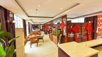 A hotel lobby with a reception desk, seating area, and decorative elements.