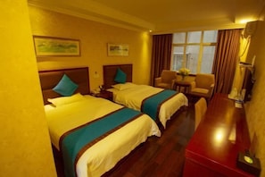 A hotel room with two beds, a desk, a chair, and a window with curtains. - Jinhao Hotel (Chengdu)
