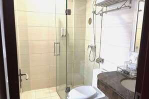 A modern bathroom with a glass-enclosed shower, a marble sink, and a toilet. - Jinhao Hotel (Chengdu)