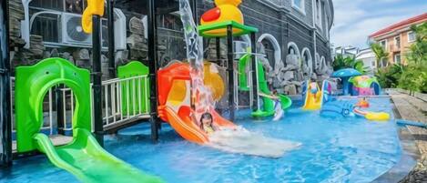 A water play area with slides and water features in front of a building.