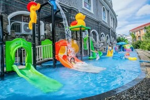 A water play area with slides and water features in front of a building. - Meilan Hot Spring Hotel (Anshun)