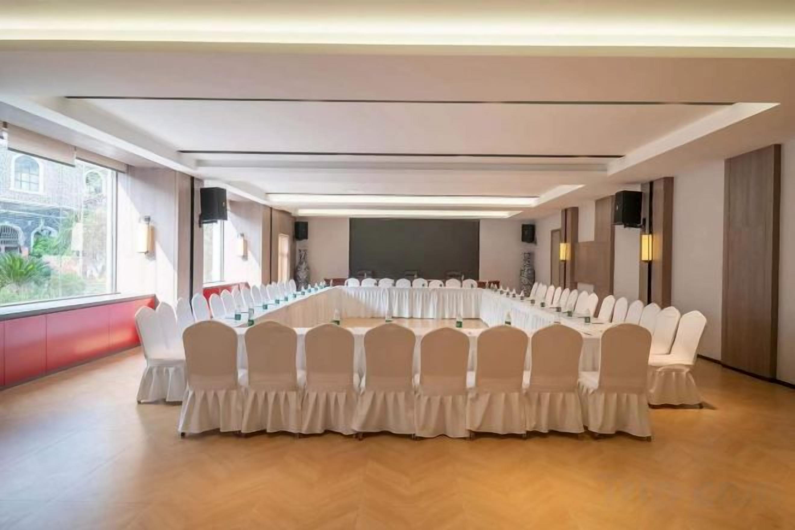 Une salle de conférence dotée d’une longue table et de chaises, de grandes fenêtres et d’un aménagement intérieur moderne.