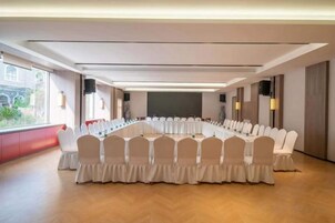 Un salón de conferencias con una larga mesa, sillas, ventanas amplias y una decoración de diseño moderno.