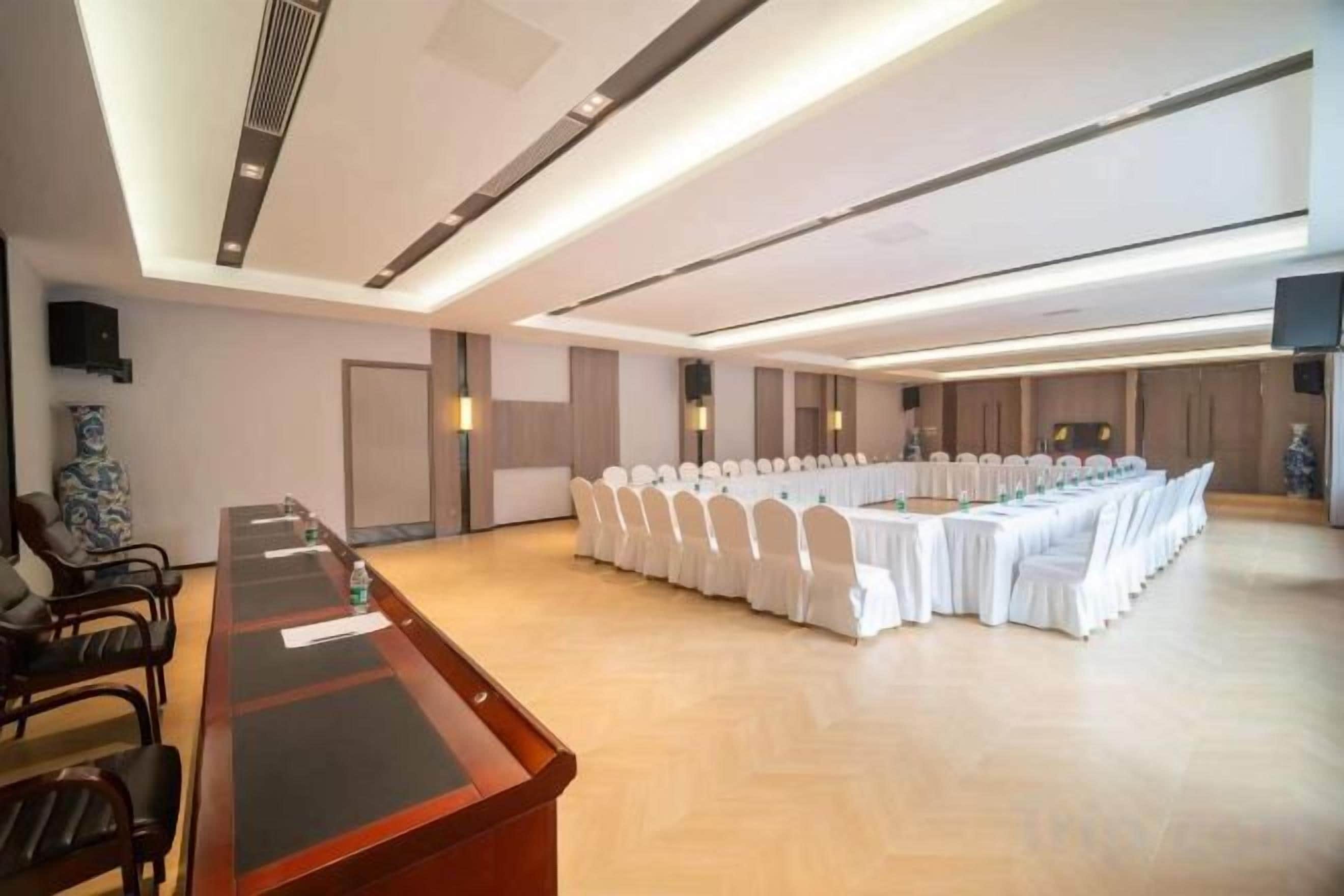 A conference room with a long table, chairs, and a white tablecloth.