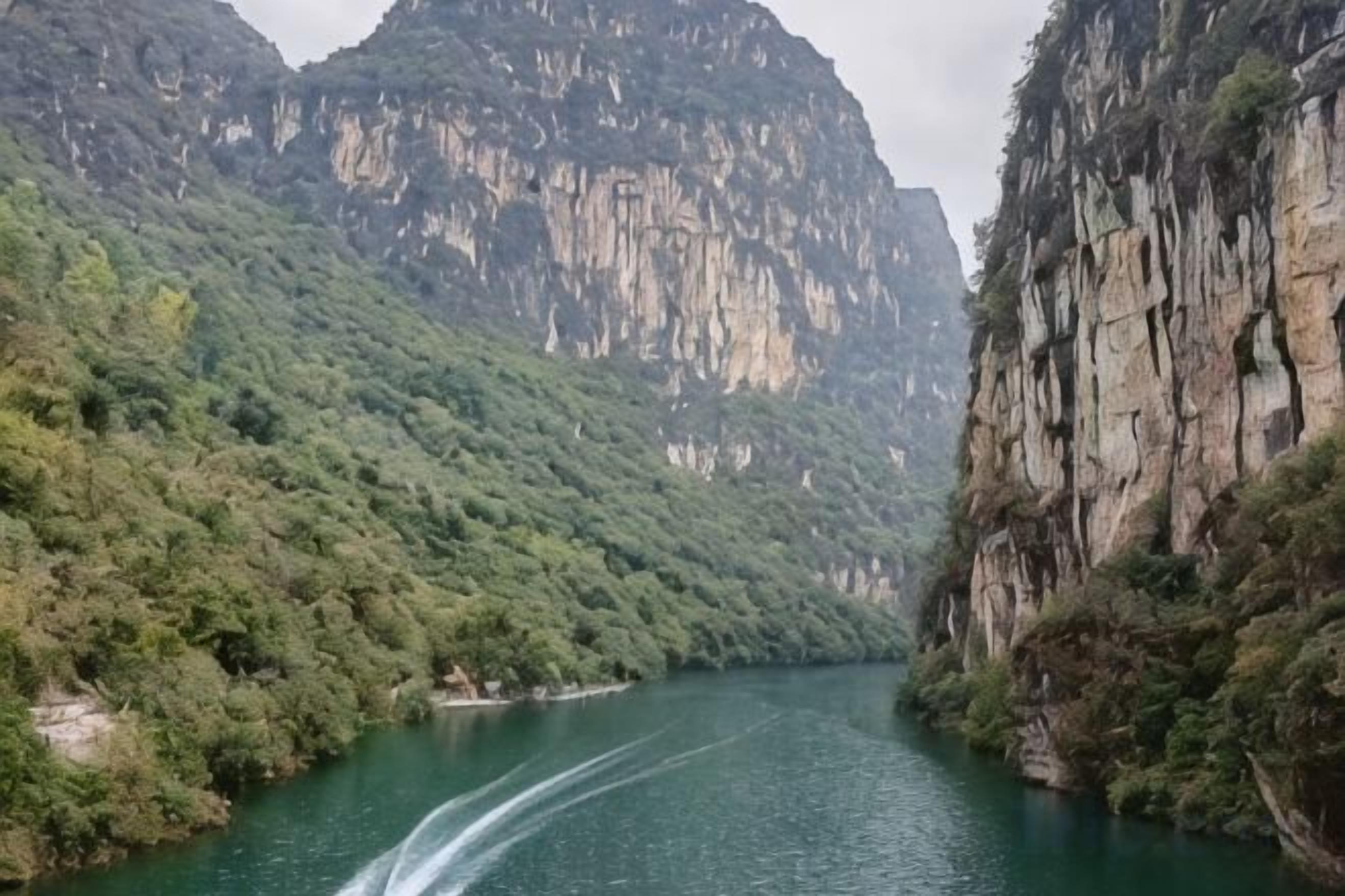 A river flowing through a mountainous area with steep cliffs on either side.