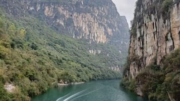 A river flowing through a mountainous area with steep cliffs on either side.