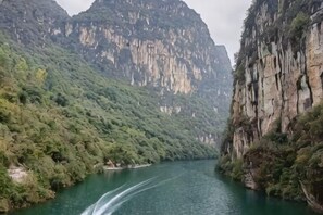 A river flowing through a mountainous area with steep cliffs on either side. - Meilan Hot Spring Hotel (Anshun)