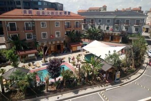 A hotel with multiple floors, outdoor swimming pool, and lush landscaping. - Meilan Hot Spring Hotel (Anshun)