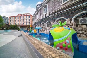 A water play area with colorful structures and a stone wall backdrop. - Meilan Hot Spring Hotel (Anshun)