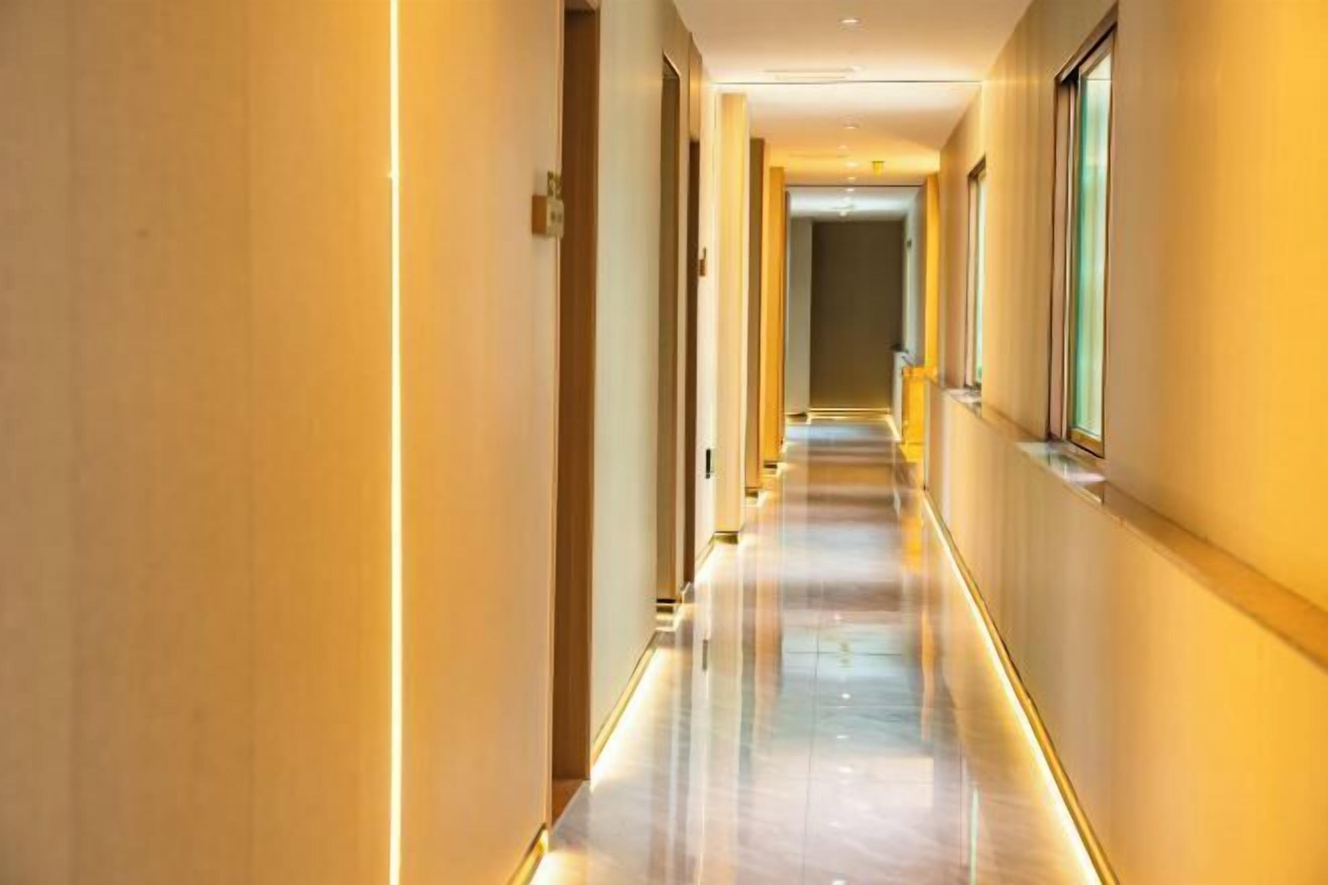 A long, well-lit hallway with a shiny floor and walls on either side.
