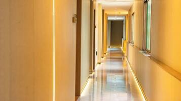 A long, well-lit hallway with a shiny floor and walls on either side.