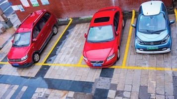 A parking lot with three cars parked in designated spaces.