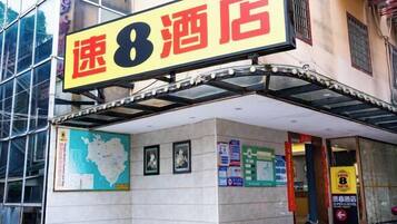 A hotel entrance with a prominent sign reading "速8酒店" (Speed 8 Hotel).