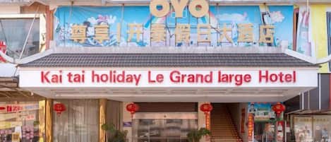 The exterior of OYO Kai Tai Holiday Le Grand Large Hotel with a traditional architectural style, a prominent entrance, and signage in both Chinese and English.