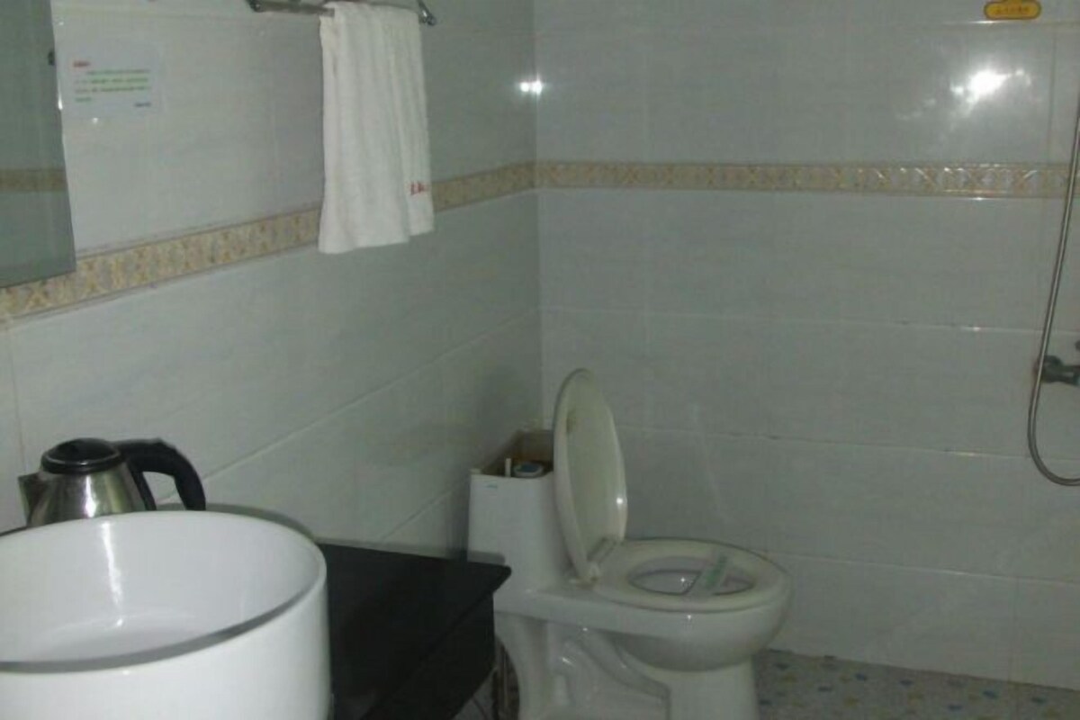 Ein Badezimmer mit Toilette, Waschbecken, Spiegel und Dusche.