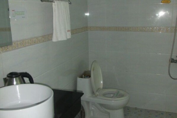 Ein Badezimmer mit Toilette, Waschbecken, Spiegel und Dusche.
