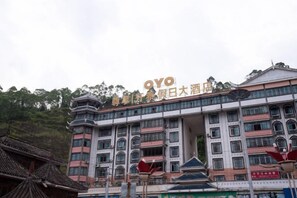 Een hotel met meerdere verdiepingen, in traditionele bouwstijl, met balkons en een opvallende ingang.