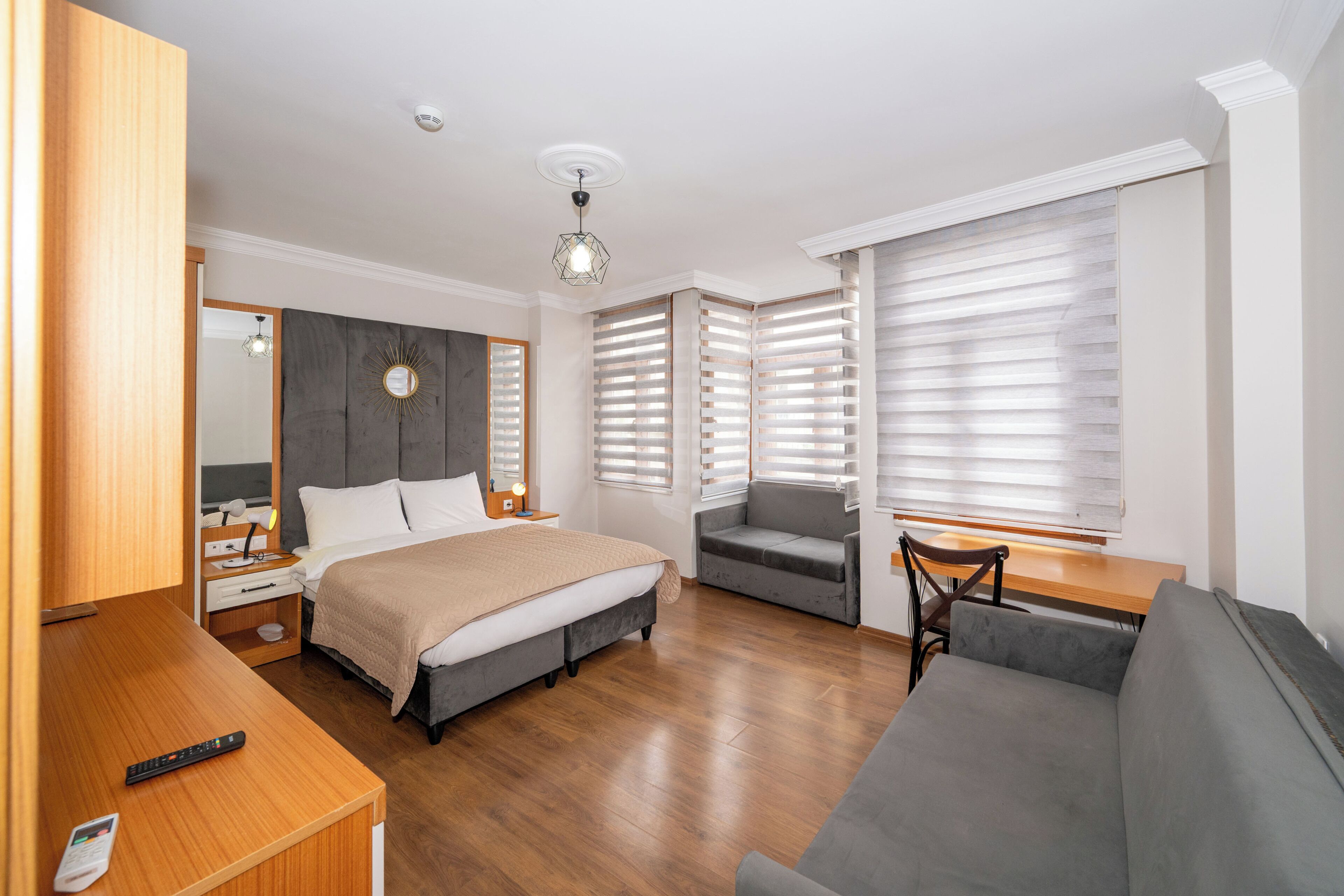 Una habitación de hotel moderna con una cama, un sofá, un escritorio y una silla.