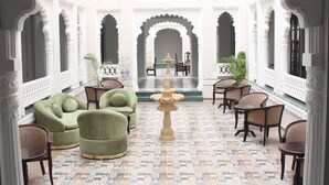 Un cortile con una fontana, un'area salotto e archi decorati.