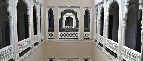 Un interior de varios niveles con arcos blancos ornamentados y balcones.