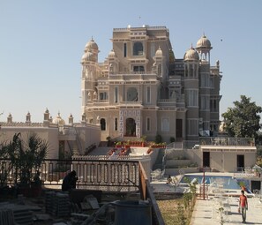 A large, multi-story building with ornate architecture, including domes and balconies. - Renest Kumbhalgarh Resort LLP (Kumbhalgarh)