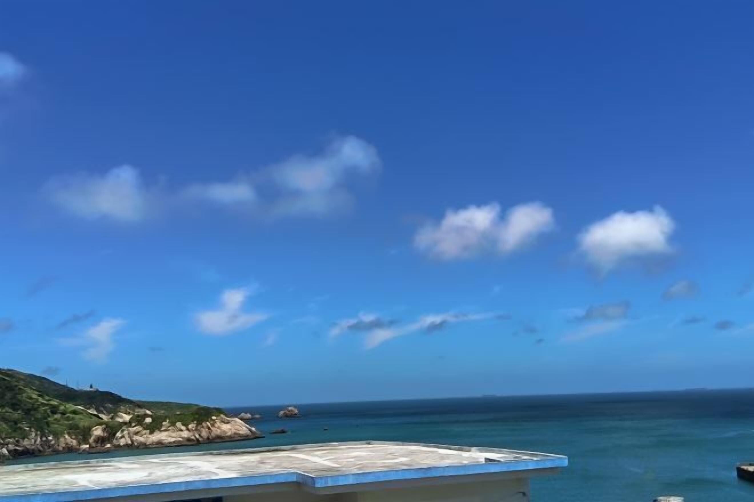 A coastal view with a clear sky and calm sea.