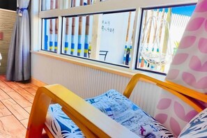 Une chambre avec un lit, une fenêtre avec des stores et une vue sur l’extérieur.