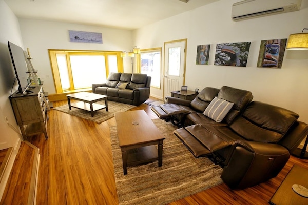 Living Room with large screen TV, power recliners, and decorative artwork from all around Southeast Alaska.