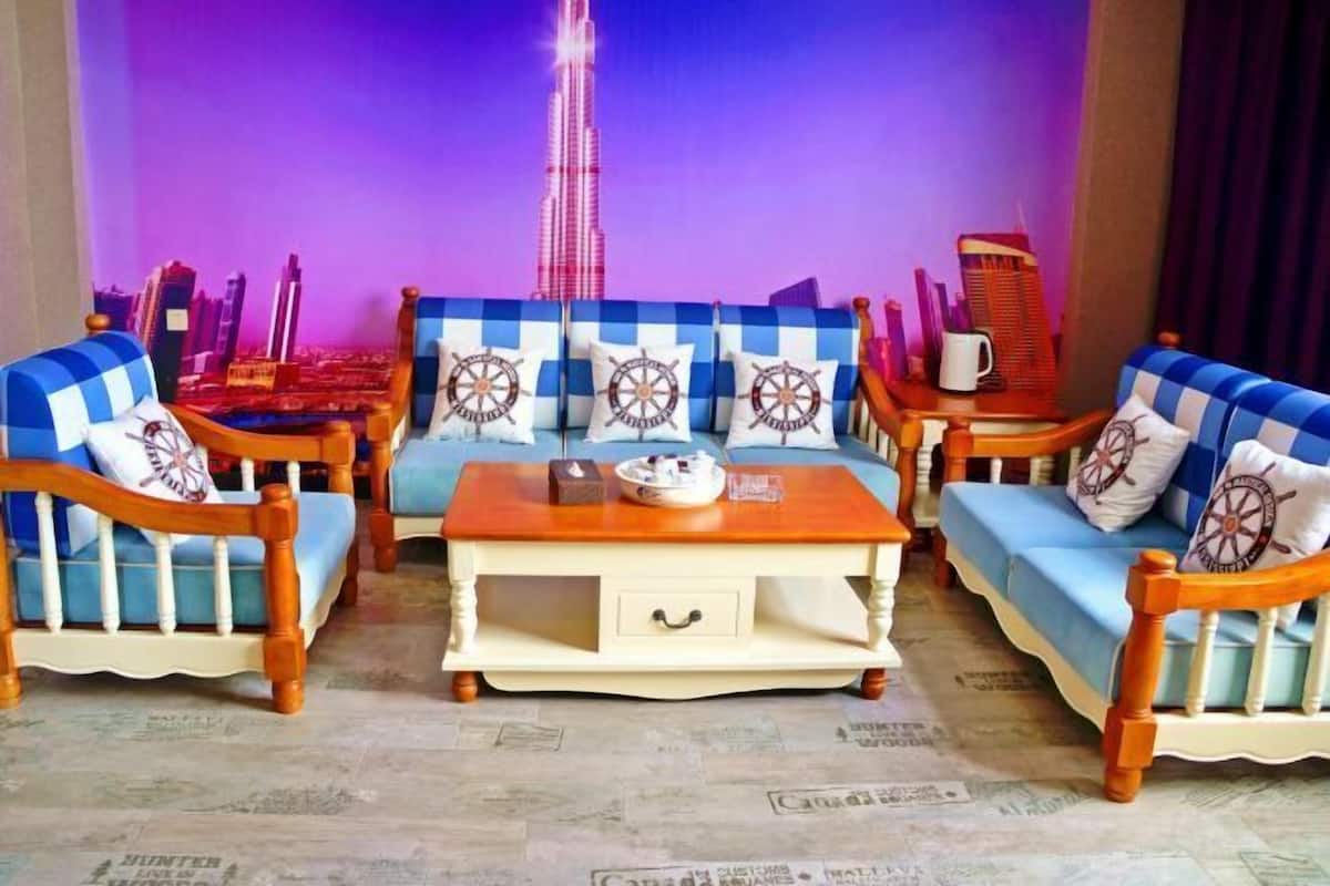 A room with a checkered sofa set, a wooden coffee table, and a backdrop featuring a cityscape with a prominent tower.