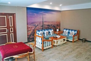 Ein Zimmer mit einer Sofaecke, einem kleinen Tisch und einem roten Sessel.