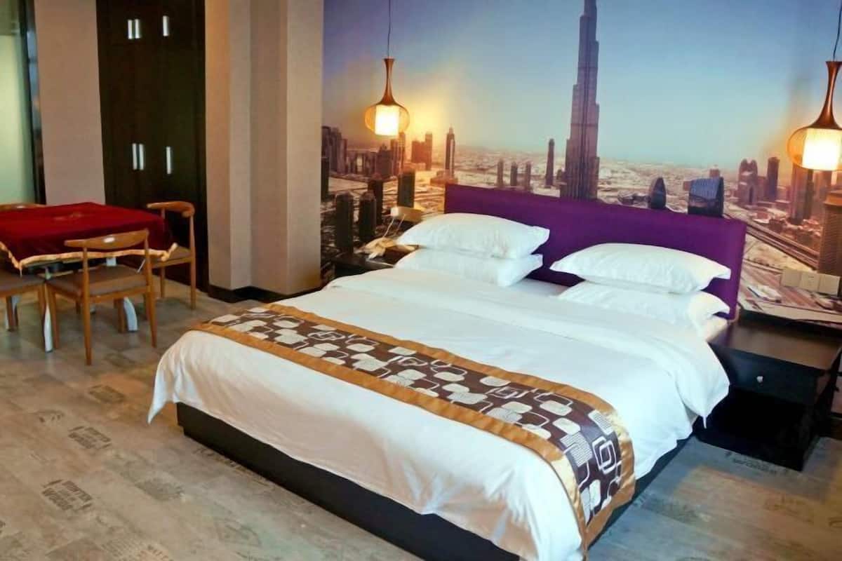 A hotel room with a bed, a desk, and a chair.
