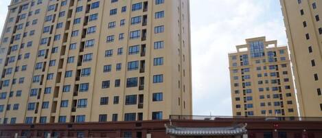A high-rise building with multiple floors and a traditional gate at the entrance.