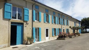 A row of buildings with blue shutters and a paved street.