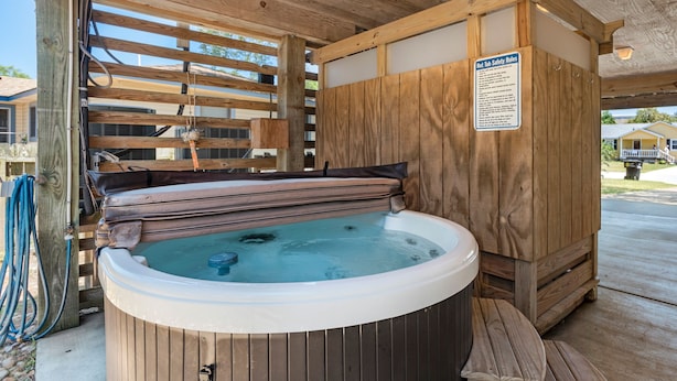 A hot tub with a wooden exterior and a sign listing safety rules. - Best Kept Secret: Soundside, Hot Tub, Dogs OK (Kill Devil Hills)