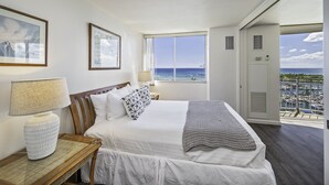 Un cuarto de hotel con una cama grande, vista al mar y un balcón con un puerto deportivo.